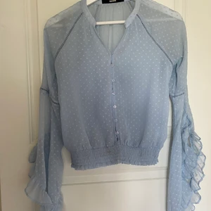 Bikbok Blus - Superfin ljusblå blus från BikBok💙 Den här utsvängda ärmar och tunt dobby mesh material samt resår vid midjan🦋 Endast använd en gång. Nypris 300kr