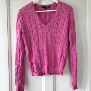  - Kabelstickad v-ringad tröja från Ralph Lauren. Köpt i en dyr vintageaffär i USA. Markerad som L men jag är stl 36 och upplever den som en 38a. Sitter lite loose på mig så det beror på hur man vill att den ska sitta på. Jättefint skick, mjuk, skön och en härlig rosa färg!  Köparen betalar frakten.