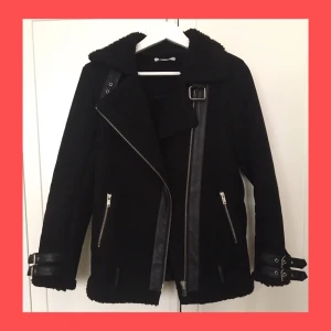  - Svart bikerjacka i fuskmocka. Kraga med slag.Två framfickor med dragkedja.  Fint skick!
