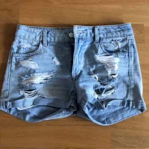 ripped jeansshorts - urtvättade jeansshorts med hål på fram och baksida, medium midja