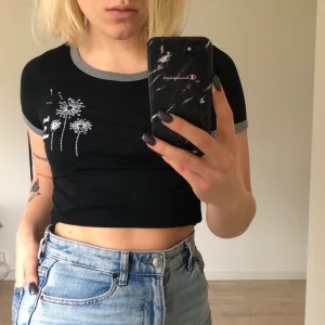 Svart topp med broderad text  - Söt topp från Hollister! Använt några få gånger men kommer inte till användning längre! Superfint broderat med blommor och text🧡 Frakt tillkommer! 