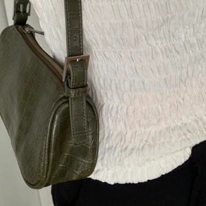 Mörkgrön väska från Ginatricot - Mörkgrön ormskinn aktig väska från Ginatricot. 