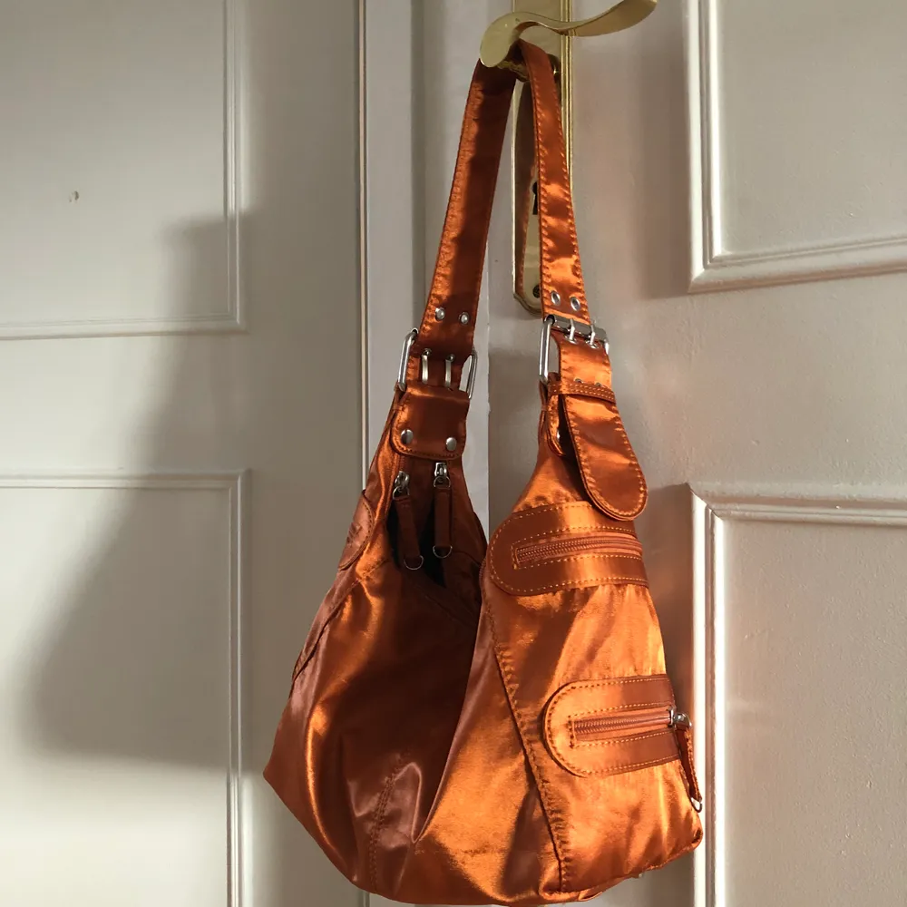 Säljer denna sjukt fina väska från ASOS som är lite metallic orange, måste sälja pga för lite användning.. den är som ny endast använd 3ggr. Jätte praktiskt med två fack i väskan + många ytterfickor! 150kr. Väskor.