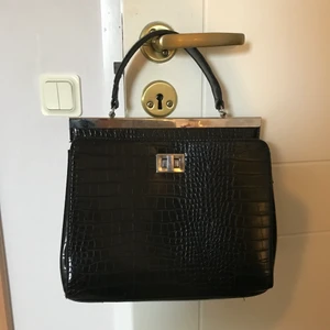 Väska i fake ormskinn  - Söt handväska med två stora fack som passar perfekt till stan eller fest. Köpt för 250kr, knappt använd! Köpare står för frakt.
