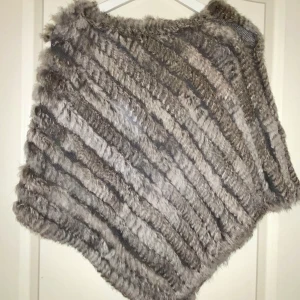 Grå pälsponcho  - Storlek 34. En grå pälsponcho med äktapäls i väldigt fint skick, knappt använd. 👍🏼