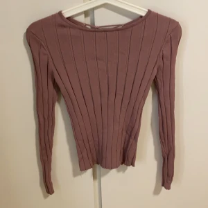 Snygg stickad tröja  - Baby lilla färg, tajt tröja har väldigt fin material med snören på baksidan, använd 1 gång 