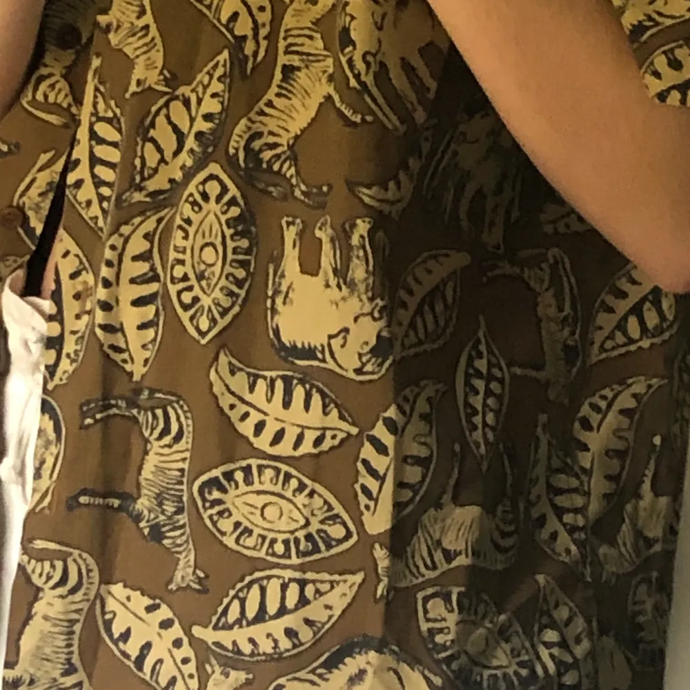 En jättecool brun kortarmad skjorta med mönster av växter och djur. Köpt på Beyond retro. Frakt på 22 kr tillkommer 🤎. Skjortor.