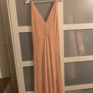 Långklänning  - Stretchig lång klänning med öppen rygg och detaljer på baksidan. Klänningen är i storlek L men den passar ett M också.