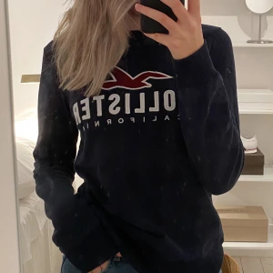 Hollister Sweatshirt  - Säljer min Hollister Sweatshirt i färgen mörkblå. Tröjan är i storlek XS men passar superbra på mig som vanligtvis har storlek S. Superskönt material, den är även i bra skick!