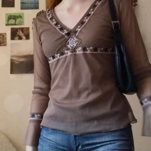 Brun 2000-tal blus - Säljer denna skitsnygga blus då jag inte har användning för den🤎 den har några lösa pärlor, annars jättefint skick. Kan mötas upp i Göteborg, annars tillkommer frakt på 44 kr :)  Budgivning avslutad.