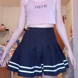 Svart kjol - Svart kjol med vita ränder. Lite tjockare tyg så kjolen har mer form och volym. 