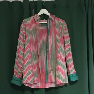 Fin färgglad skjorta med rosa, gröna, svarta och vita ränder samt vita prickar på kanterna. Vill få bort den så priset kan diskuteras 