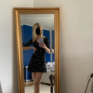 Svart kläning med röda/rosa roser med volang längst ner - Super fin och gullig klänning från nobody’s child. Säljer den för att jag aldrig har användt den tyvärr:/ Är en XS men den passar också en S då den är väldigt stretchig Frakten (42kr) ingår i priset😍 