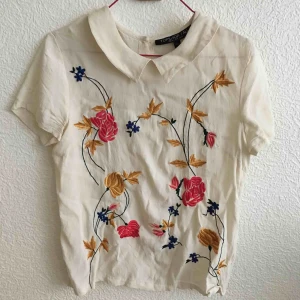  - Blus från Topshop. Knappar längst ryggen. Blommorna på framsidan är fastsydda.   Köpare betalar frakt eller möter upp i Malmö. 