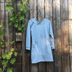  - Kort ”hoodieklänning” med fickor. Relativt tunt tyg. Öppningsbar dekorationsdragkedja vid ena axeln. Slutar ca mitt på låren. Märkt M men passar S.