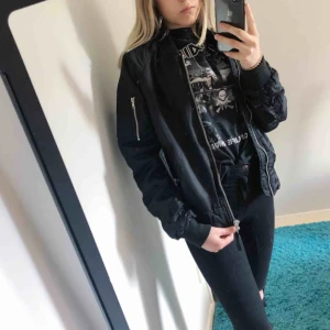  - Bomberjacka med oranget innerfoder. Storlek S (herrstorlek), oversized på mig som vanligtvis har storlek S (damstorlek). Skulle säga att den skulle passa en dam M eller herr S. Tjockare jacka, passar bäst till hösten eller kyligare dagar. Från Carlings.