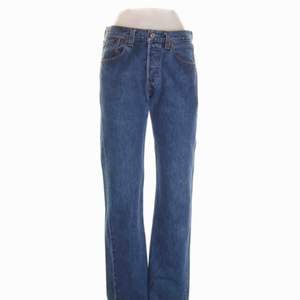 Blå Levis jeans modell 501 i kraftigt jeansmaterial. Knappgylf. Storlek: 29/32 Innerbenslängd (cm): 80 Midjemått (cm): 74