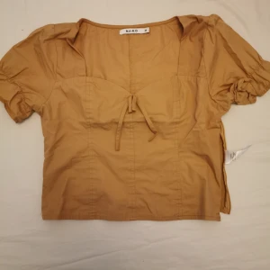  - Snygg beige topp från NAKD. Använd max 3 gånger. Dragkedja vid sidan så den sitter snyggt vid midjan. 