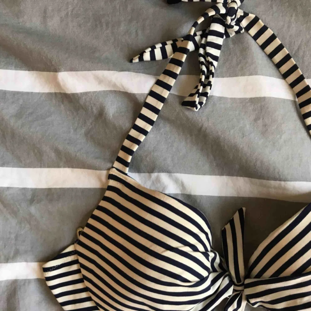 Bikinitoppar. 30 kr styck. En blå och vit, och en i samma modell fast svart. Knytes runt halsen med vanligt spänne i ryggen. . Övrigt.