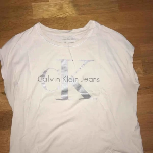  - Calvin Klein t-shirt säljes. Endast använd 2-3 gånger. Den är i en kortare modell men inte en magtröja.  Passar även en S. 