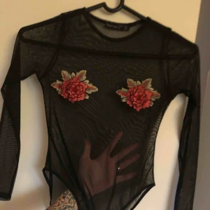  - ”Genomskinlig” body med rosor över brösten använd vid två tillfällen.