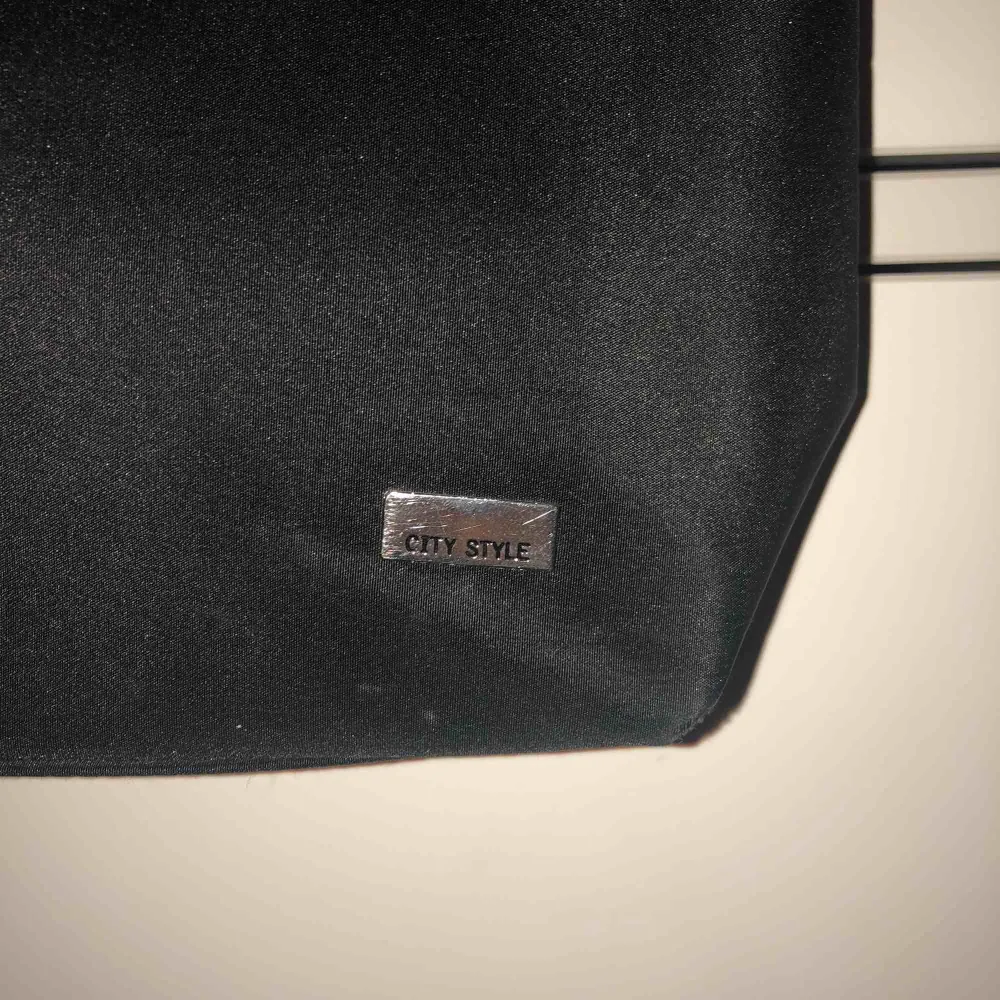 Snygg svart väska i lite silkesaktigt material. Finns flera olika fack! Kan skicka fler bilder om det behövs :) möts upp i Stockholm alternativt att köparen betalar frakt. Väskor.