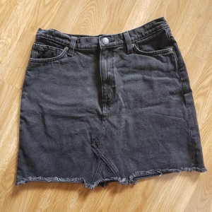  - Svart/grå jeanskjol med fransad kant. Strl 40, har dock krympt en aning i tvätten. Frakt 20kr🌿