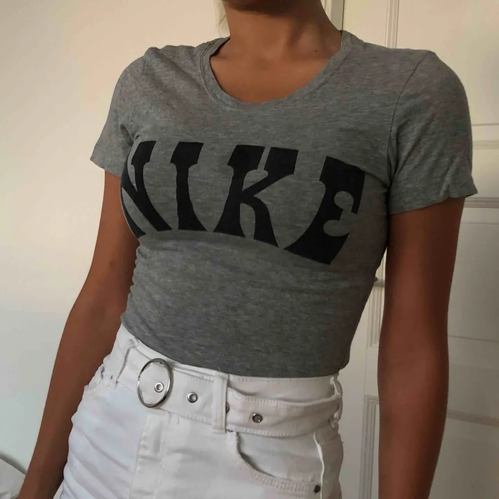 Grå snygg T-shirt från märket Nike i storlek XS. Tröjan är i nyskick förutom att det finns en fettfläck längst ner vid sömmen. Denna går att tvätta bort och det är inte svårt att dölja den. Kan mötas upp i Lund eller så står du som köpare för frakt ❤️. T-shirts.