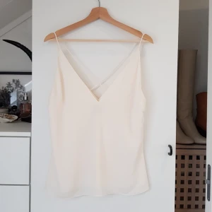  - V neck med korsad rygg, super snygg och perfekt till sommaren! Vit/gräddvit färg, storlek 40 Frakt betalas av köparen eller så kan vi träffas vid centralen eller täby centrum!