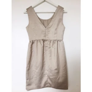  - Klänning med v-ringad rygg och dold dragkedja. Använd 1 gång. Jättefin till gäst på sommarbröllop! 