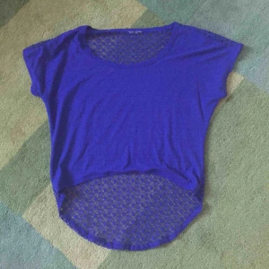  - Cool topp i vacker blålila färg. Transparent baksida och även längre baktill än framtill.
