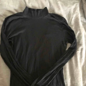  - En sjukt snygg svart ribbad polotröja med öppen rygg. Kommer från Nelly och endast använd ett par gånger så är i väldigt bra skick