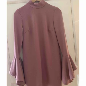  - Fin klänning med utsvängande armar och lite högre vid halsen. Jättefin med ett midjebälte till! Aldrig använd endast testad(!!!) Ordinarie pris 249kr! Hämtas i Gävle eller fraktas, fraktkostnad tillkommer🌸