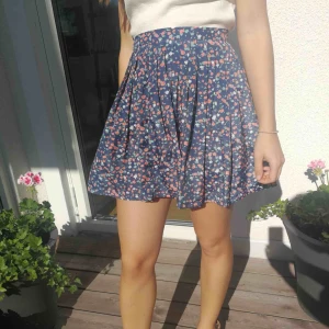  - Kjolen är som en S men är ganska stor i midjan. Jag använder en säkerthetsnål för att den ska sitta bra. Man kan sy in den om den inte passar. För mig funkar en säkerhetsnål. 