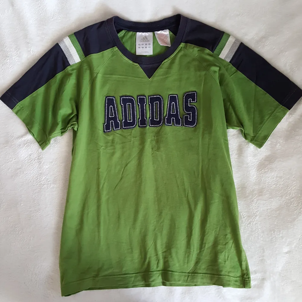 Vintage grön Adidas t-shirt i fint skick. Står storlek 164 på lappen men är som ca storlek S/M. Kan skickas om köparen står för fraktkostnaden som blir 36kr. . Övrigt.
