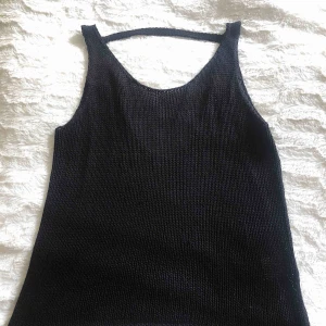  - Stickat/virkat svart linne, väldigt mjukt material som inte sticks, öppen övre rygg med band över nacken, ”flowey” passform