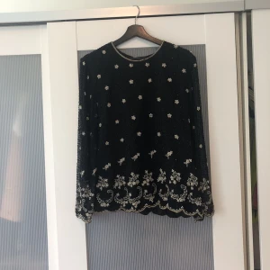  - Passar allt från S-L beroende på hur man vill att den ska sitta. Sjukt fin blus i silke, pärlbroderad. Använd ett fåtal gånger och är i perfekt skick. Perfekt till fest. Den har helt amazing detaljer.