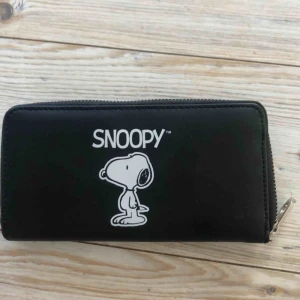  - En ganska stor plånbok med ett motiv på Snoopy.