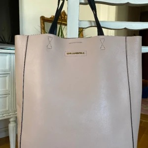 Karl Lagerfeld väska  - Karl Lagerfeld väska i äkta läder. Färg gammaldags rosa. Använd 1 gång och köpt för cirka 2400 kr. Går att hämta i Majorna, centrum eller fraktas mot avgift.  Inga fläckar eller defekter. Höjd 38 cm. Bredd 32 cm, djup 12,5 cm.