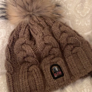 Äkta Parajumpers mössa i nyskick! - Äkta parajumpers mössa köpt på Johnells med fungerande äktighetskod. Säljer då jag fick den i julklapp men inte är min stil. Har inte kvitto men somsagt en giltig äkthetskod som verifierats av Parajumpers (se bild 3). Modellen: Cable Knit Beanie 