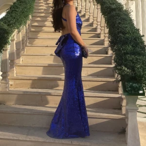 Balklänning💙💙 - En jättefin blå paljettklänning perfekt till balen. Köpt i Storbritannien från märket godiva. Öppen i ryggen med en rosett baktill. Använd endast en gång och i perfekt skick. Pris går att diskutera💗