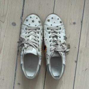 Ed Hardy skor - Säljer mina skor från ed Hardy! Dem är använda och saknar en silvrig detalj på framsidan av högra skon. Är lite smutsiga men går lätt att tvätta därav det låga priset🩷 Storlek 40!