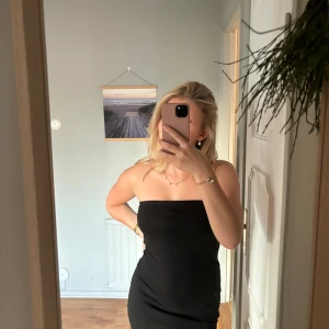 Svart bandeau  klänning - I nyskick och har en smal silikon rand innanför klänningen för att hålla uppe den bättre