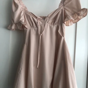 Klänning - Puderrosa kort klänning från  NA-KD, puffärmar och puffig nederdel. Fint skick. Stl 32 (xs)