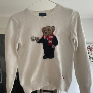 Stickad ralph lauren tröja - Nästan oanvänd då den är för liten, den är XL barnstorlek. Den är helt felfri bortsett från en liten slitning på björnens halsduk