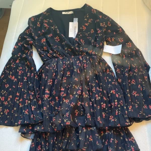 Minidress  - En söt svart klänning med röda blommor Nyskick och oanvänd