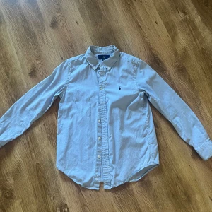 Ljusblå Ralph Lauren - Ljusblå skjorta perfekt på sommaren  Storleken är 16 vilket motsvarar 164