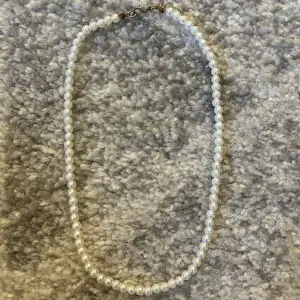 Ett pärlhalsband med vita pärlor, använt ett par gånger. 