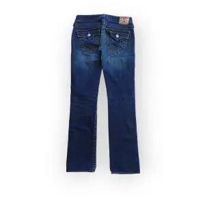 Raka lågmidjde jeans from True Religion. Bra skick, inga defekter förutom revorna som lappats igen på baksidan. Passar XS/XXS eller 32/34. Fråga gärna om fler bilder eller mått 💞