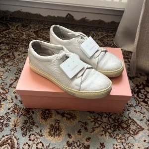 Acne Studios Sneakers 😫🔥🤍 - sjukah acne sneakers skor med en stor jävla logga shmäckad rakt på boom!🫥🫥🫥🫥🫥🫥 sjuka o sjukt rare lite äldre modell i äkta läder😫🔥 kolla priset med, suttit i garderoben ett bra tag nu så var dags för luft. bra skick💯 storlek 39